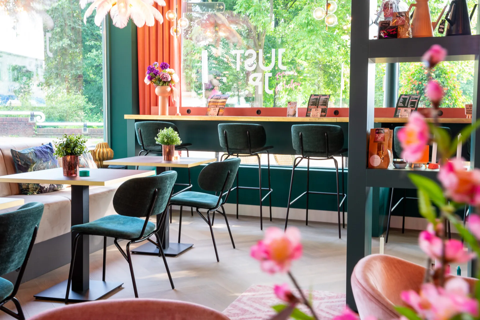 Interieur van lunchroom Just JP met groene stoelen en bloesemboom